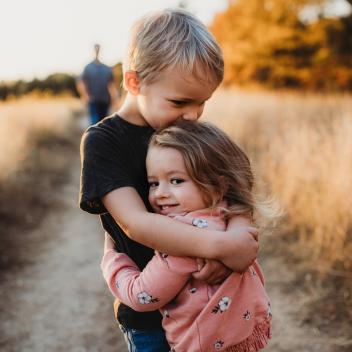 Two children hugging on a pathway