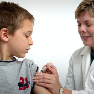 Young boy receiving a vaccination from a doctor